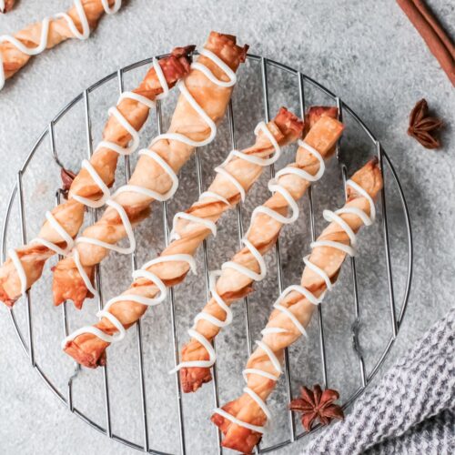 Apple puff pastry twists on a wire rack.