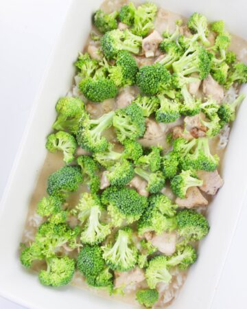 A casserole with rice, cooked chicken, and broccoli with a creamy sauce.