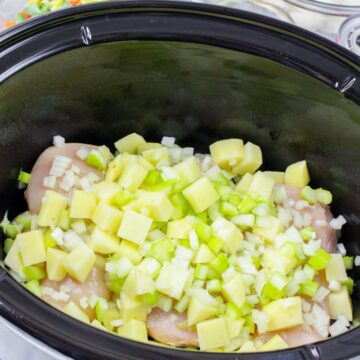Chicken, potatoes, and celery in a slow cooker to make chicken pot pie in the slow cooker.