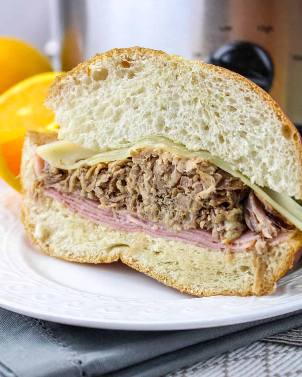 A half sandwich of a Cuban pork sandwich made in the slow cooker.