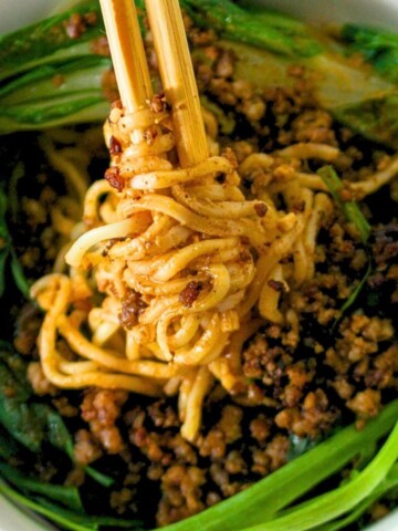 A bowl of bok choy, cooked pork and noodles to make Dan Dan noodles.