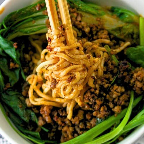 A bowl of bok choy, cooked pork and noodles to make Dan Dan noodles.