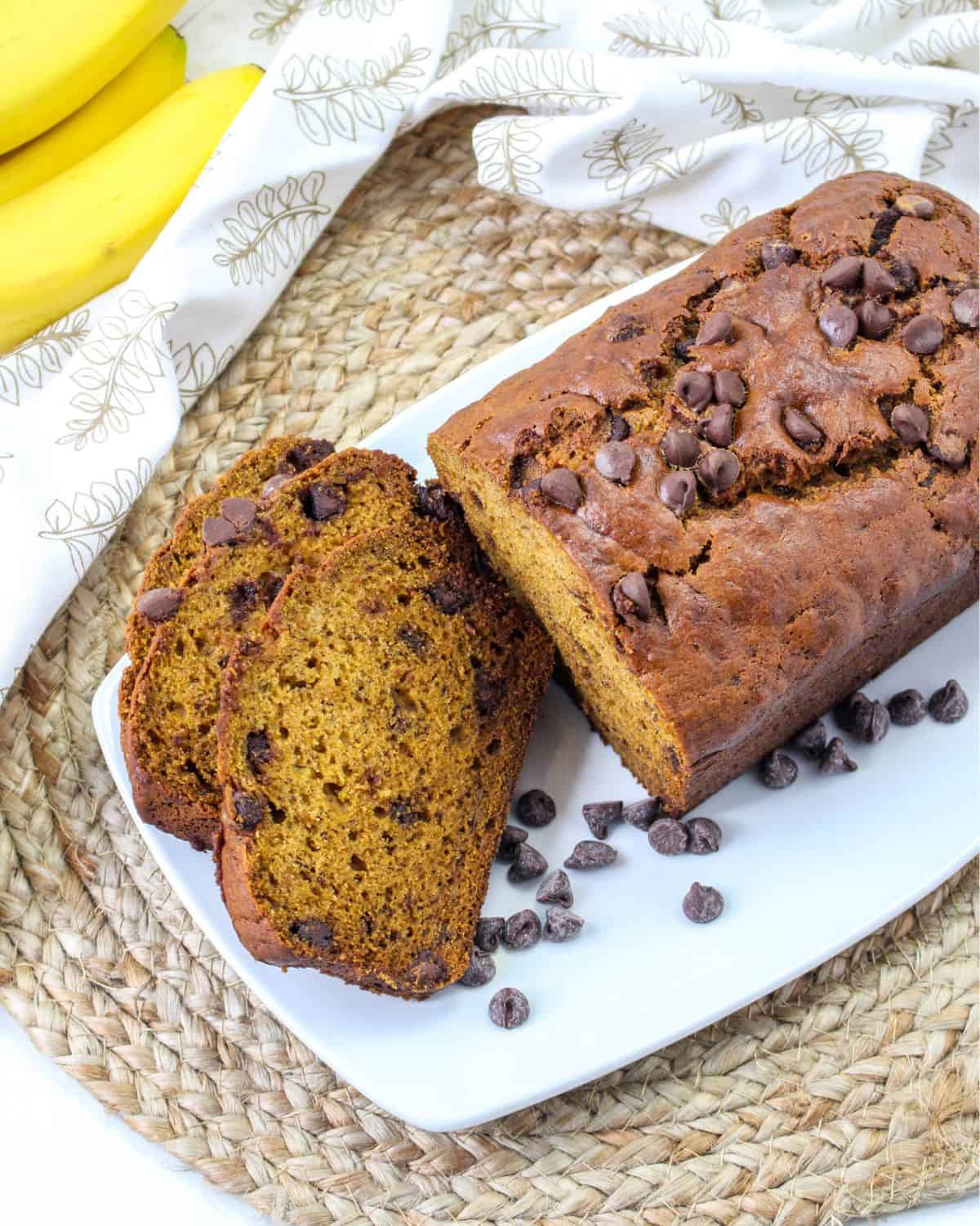 A loaf of pumpkin banana bread sliced on a plate.