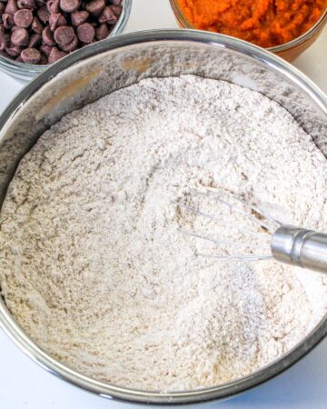 A large mixing bowl with dry ingredients to make a pumpkin banana bread.