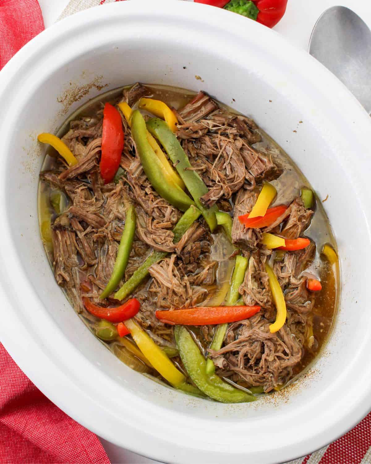 Slow Cooker Shredded Beef and Peppers in the vessel of a slow cooker.