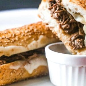 A french dip with melting cheese and shredded beef.