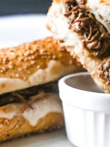 A french dip with melting cheese and shredded beef.