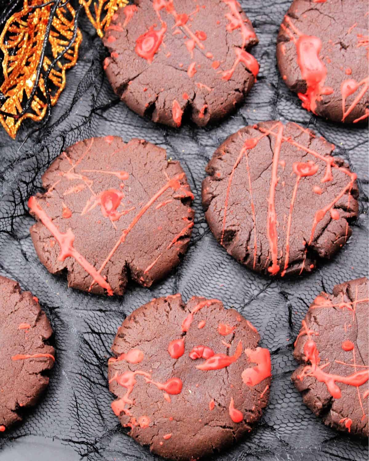 Blood splatter cookies on a black mesh sheet.