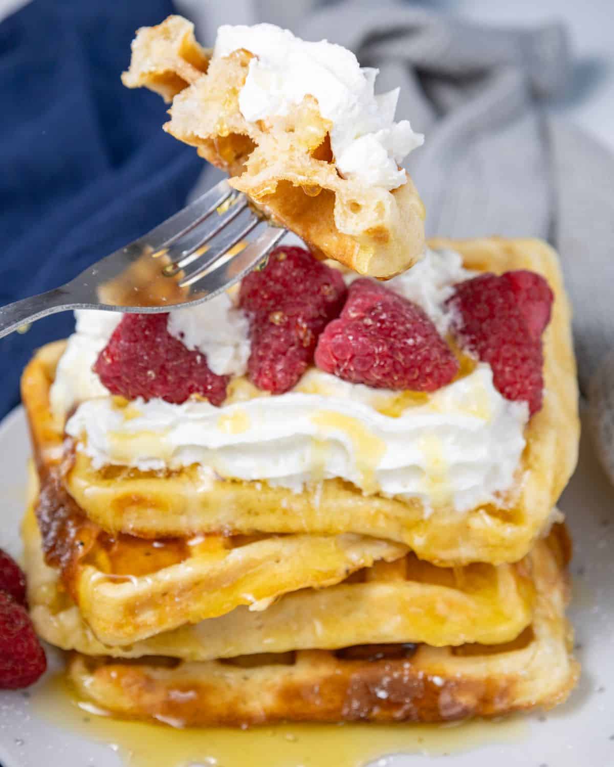 A recipe for eggo waffles made at hope topped with whipped cream and raspberries.