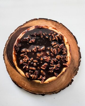 A cheesecake with pecan pie topping.