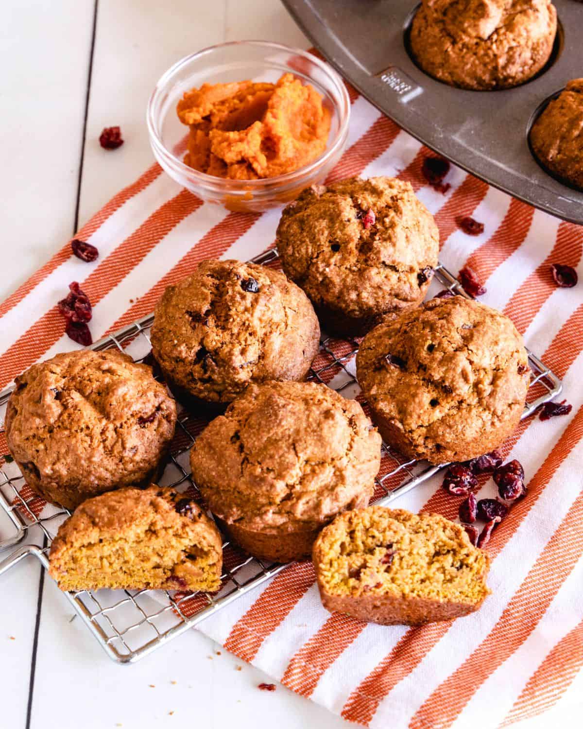 Cranberry pumpkin muffins on a striped linen napkin.