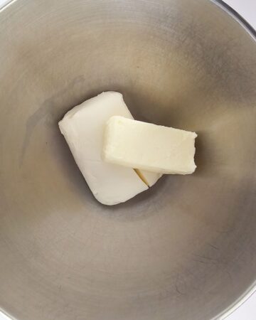 Cream cheese and butter in a mixing bowl.