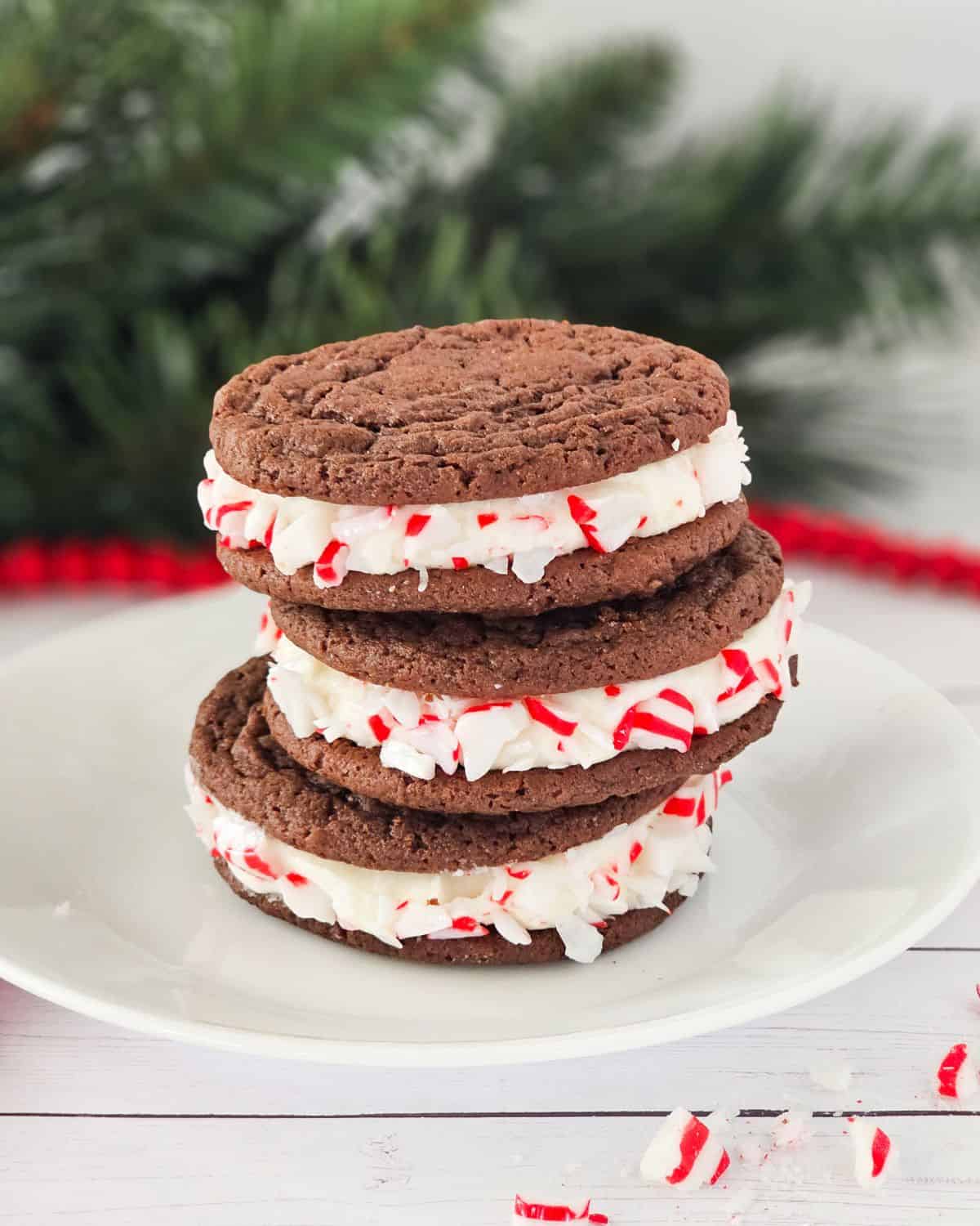 A peppermint chocolate sandwich cookie with a creamy filling with chopped peppermint crunchies on the side.