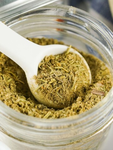 Homemade poultry seasoning in a glass jar.