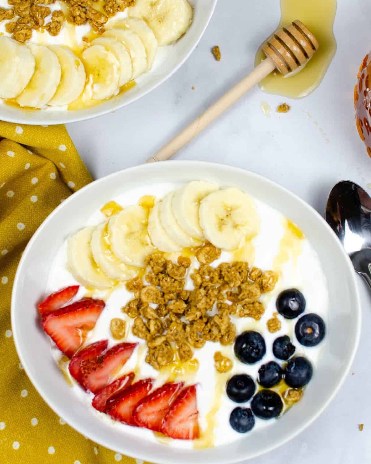 Instant pot greek yogurt in a bowl with bananas, granola, and berries.