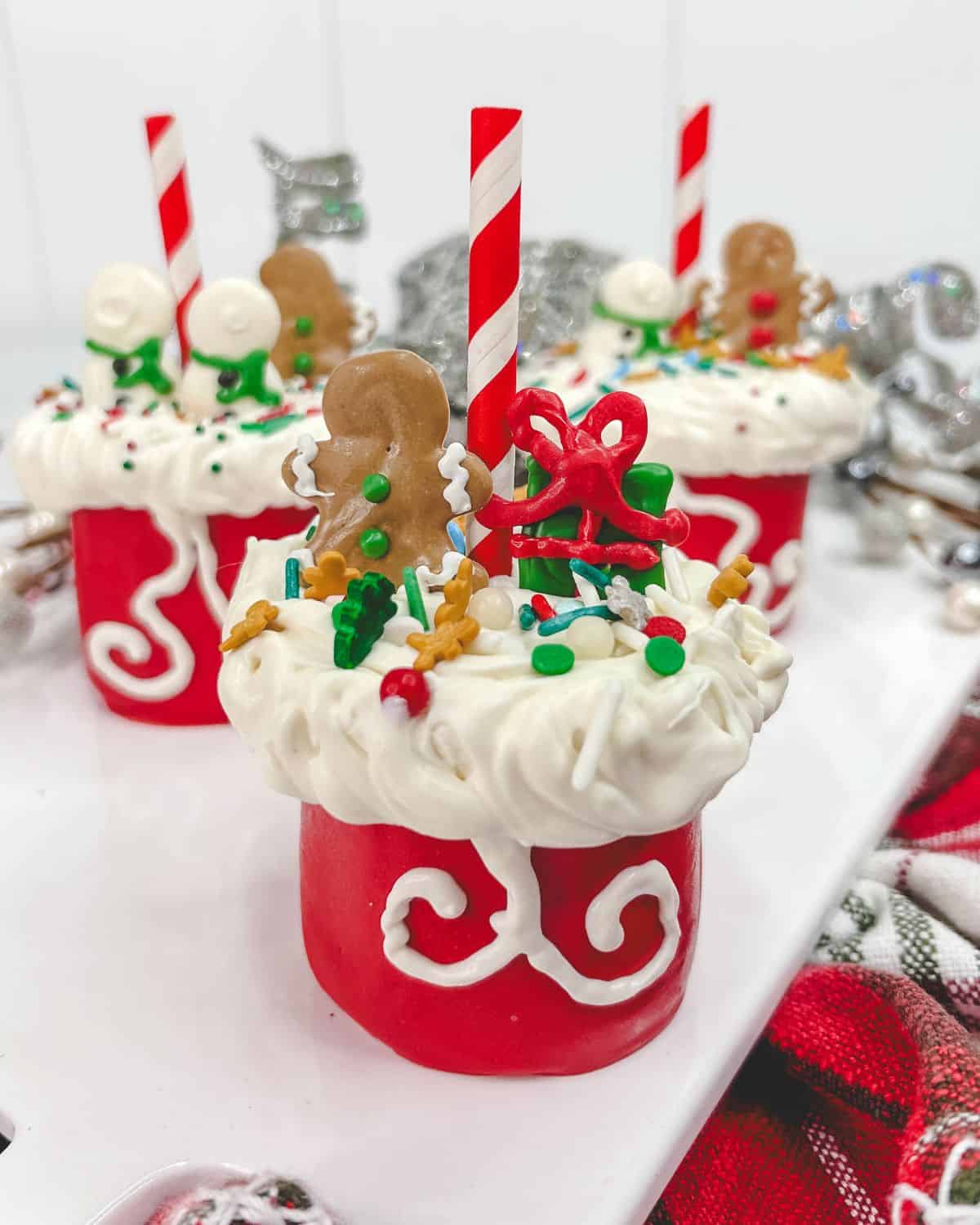 Santa bag marshmallow pops decorated with sprinkles and candy snowman.