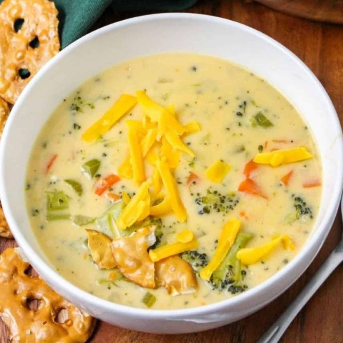 A bowl of broccoli beer cheese soup with shredded cheese.
