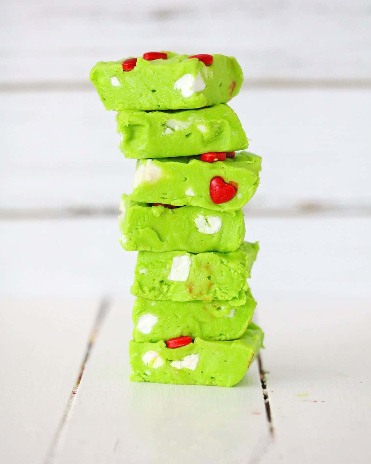 Grinch fudge stacked up on a white plate. 