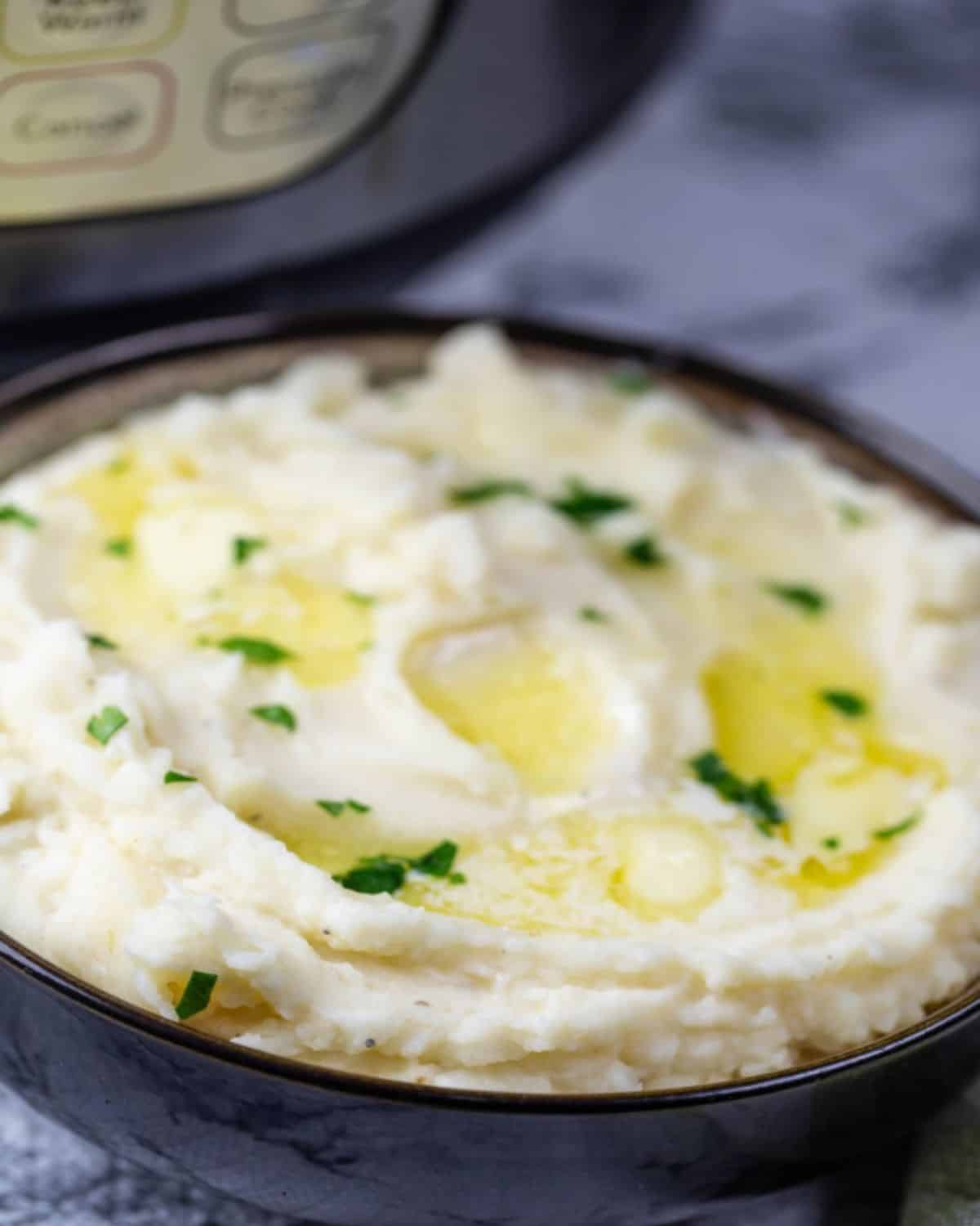 A bowl of buttermilk mashed potatoes in front of an Instant Pot.