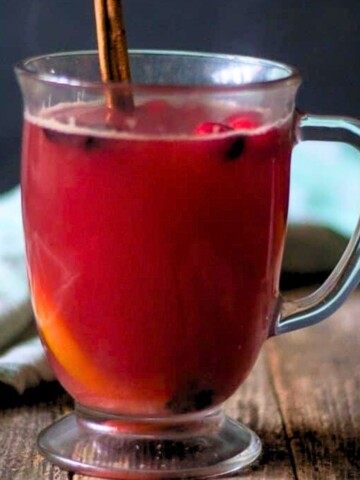 Warm cranberry punch in a clear mug.