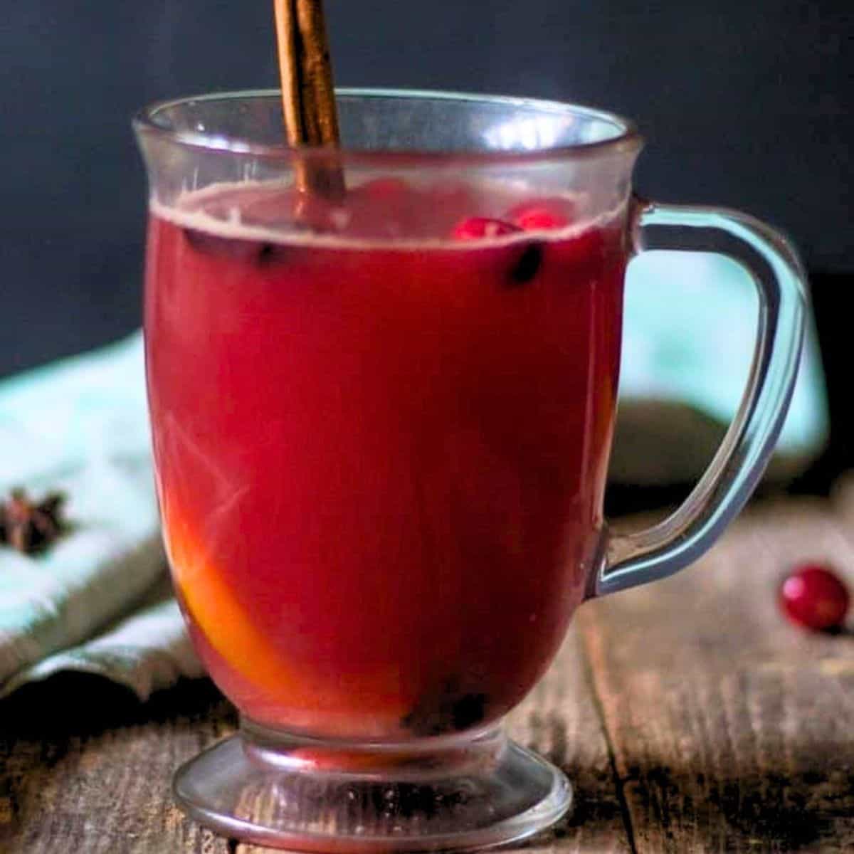 Warm cranberry punch in a clear mug.