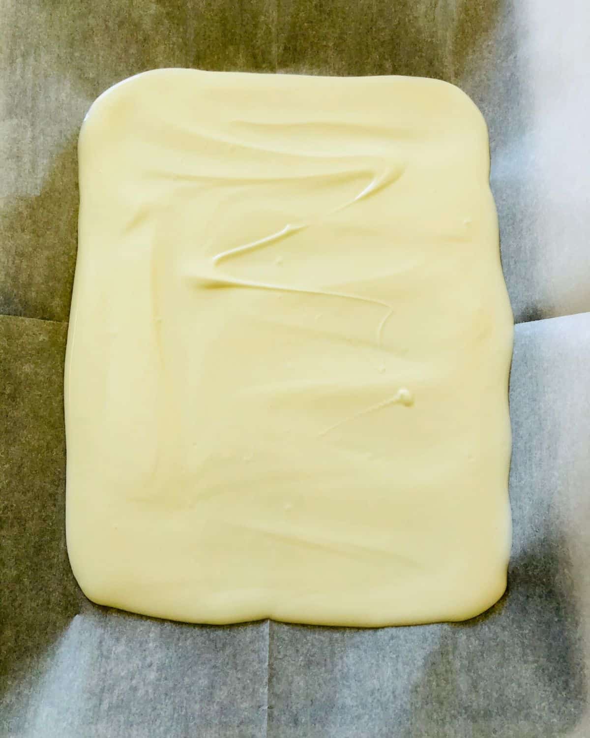 White chocolate that has been melted on a baking sheet.