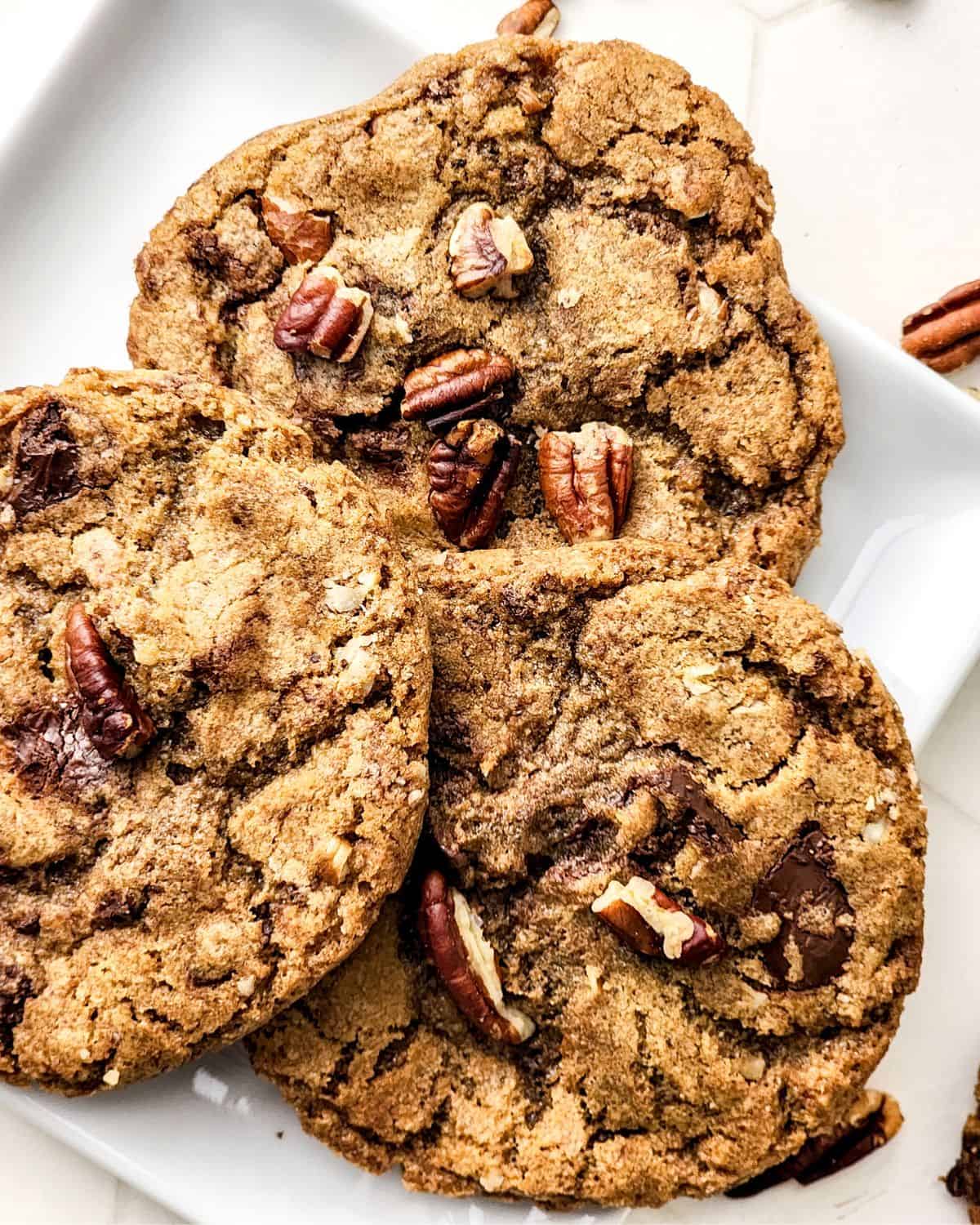 Brown butter pecan chocolate chip cookies on a plate.