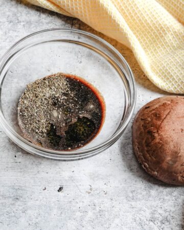 A bowl with soy sauce, and other ingredients to make a marinade for portobello mushrooms.