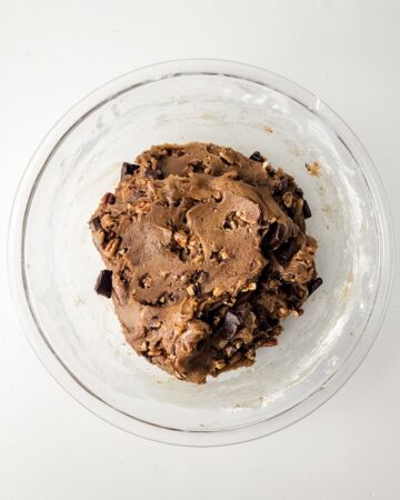 A glass bowl with brown butter pecan cookie batter in the bowl.