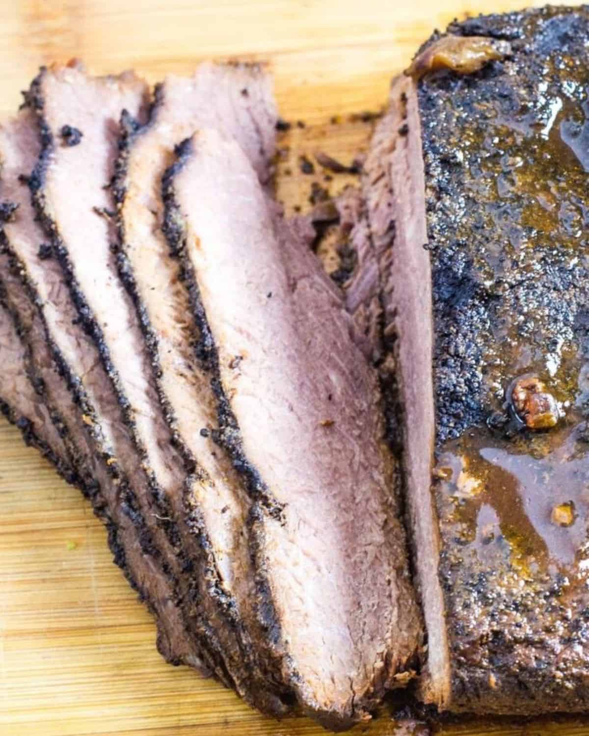 Sliced beef brisket on a cutting board that was made in the slow cooker.