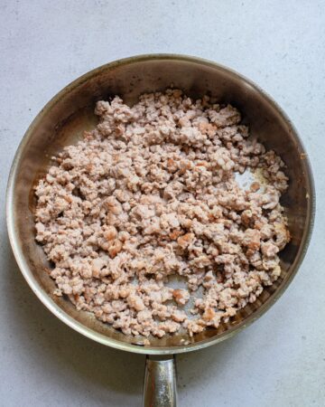 Ground pork in a saucepan that has been browned.