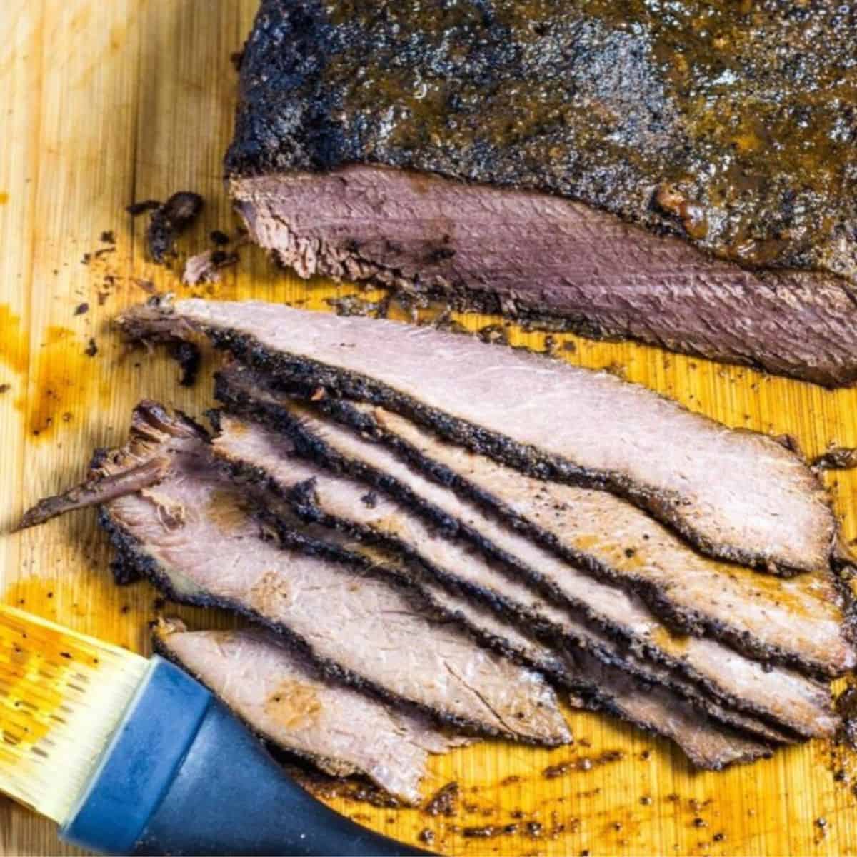 Slow cooker coffee rub beef brisket on a large cutting board.