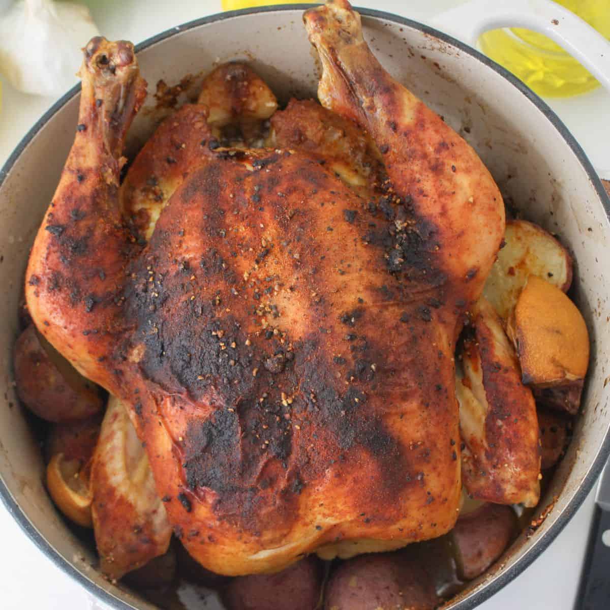A roasted chicken and potatoes made in the Dutch oven.