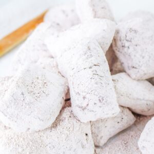 Beignets that have been fried and covered with confectioners sugar and are chocolate flavored.