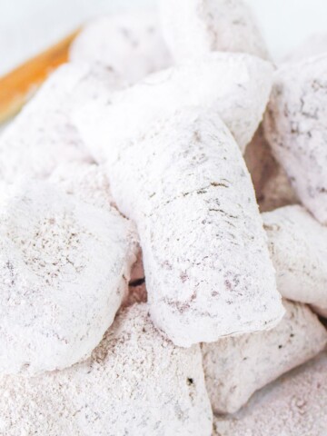 Beignets that have been fried and covered with confectioners sugar and are chocolate flavored.