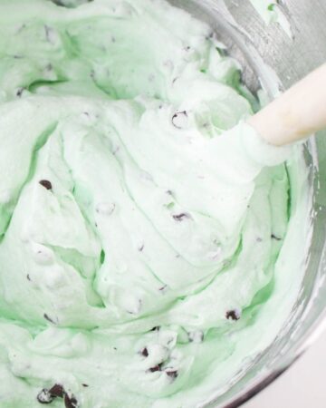 Grasshopper ice cream being mixed in a large silver mixing bowl.