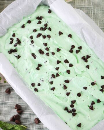 A large loaf pan of homemade grasshopper ice cream with chocolate chips.