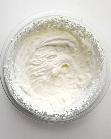 A large mixing bowl with whipped heavy cream in the bowl.