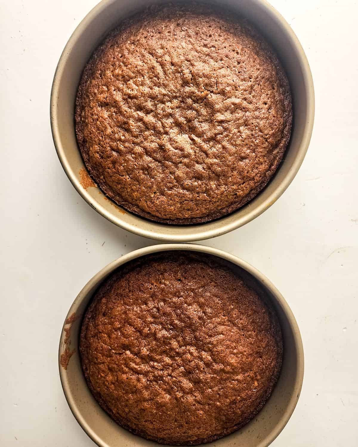 Round baking pan with baked carrot cake in them.