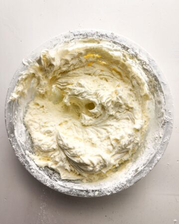 A mixing bowl with cream cheese frosting in the bowl.