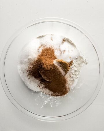 A large mixing bowl with dry ingredients to make carrot cake.