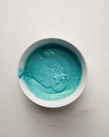 A bowl of cheesecake mixture with blue food coloring for an easter egg cheesecake.