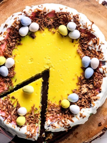 An easter cheesecake with robins eggs on top with a slice cut from the cake.