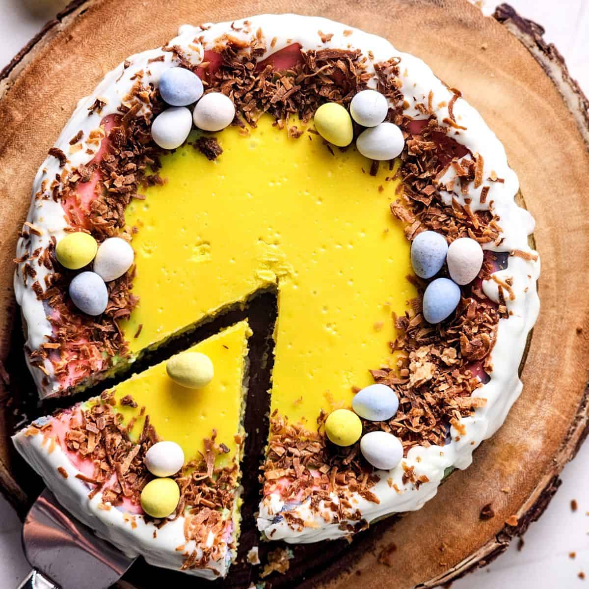 An easter cheesecake with robins eggs on top with a slice cut from the cake.