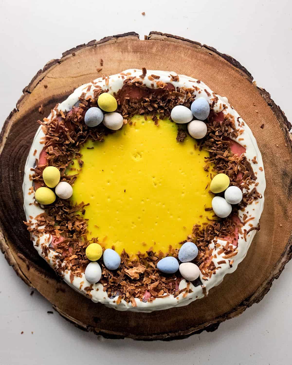 A cheesecake for Easter topped with Cadbury eggs and toasted coconut.