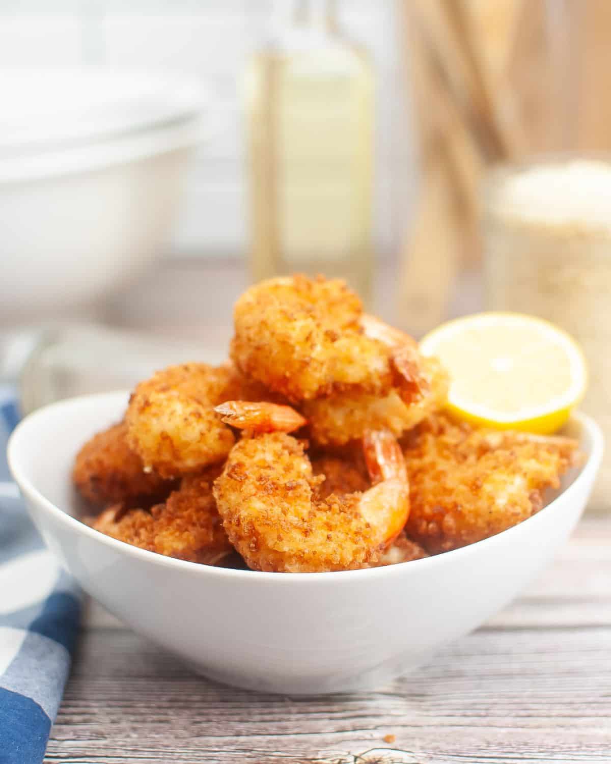 A bowl of Panko fried bread crumbs with a lemon wedge.