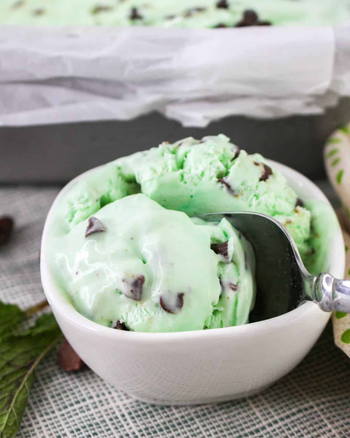 A bowl of homemade no churn grasshopper ice cream with chips.