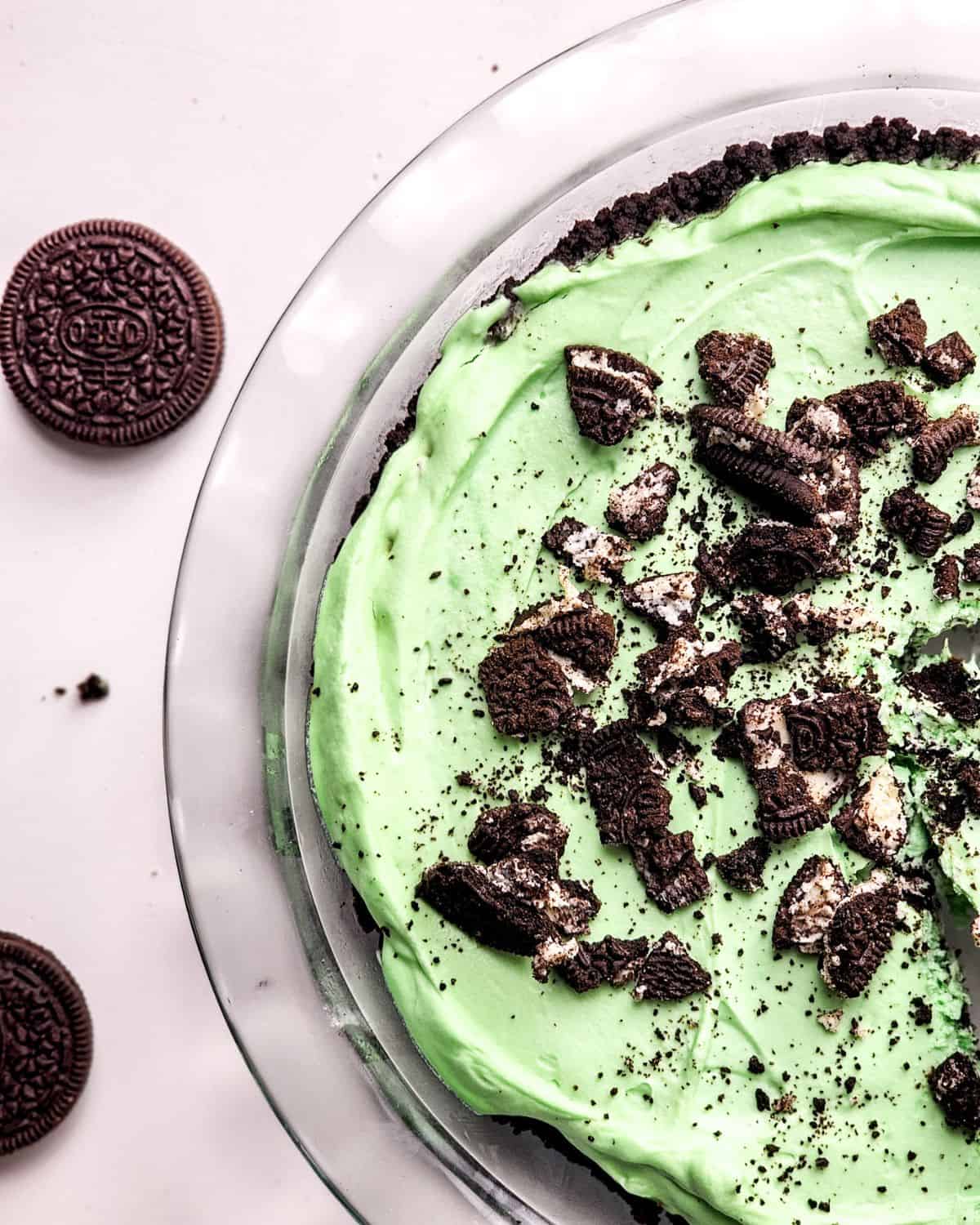 A Mint Pie with an Oreo crust topped with crumbled oreo cookies on a white table.