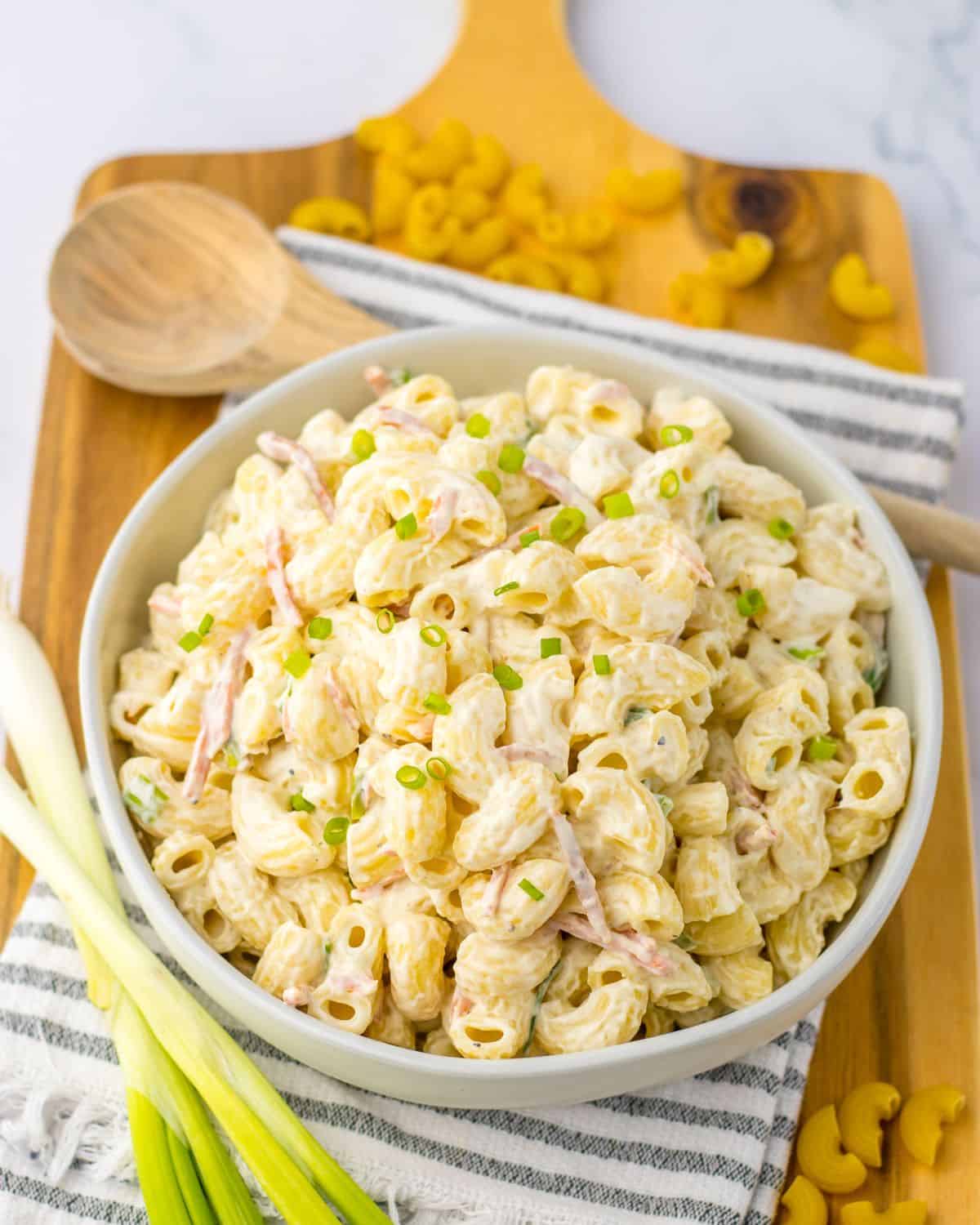 Hawaiian Macaroni Slad in a bowl on a wooden platter. 