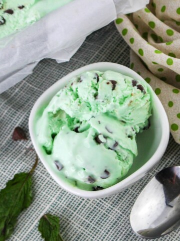 No churn grasshopper ice cream in a bowl with mint leaves on the side.